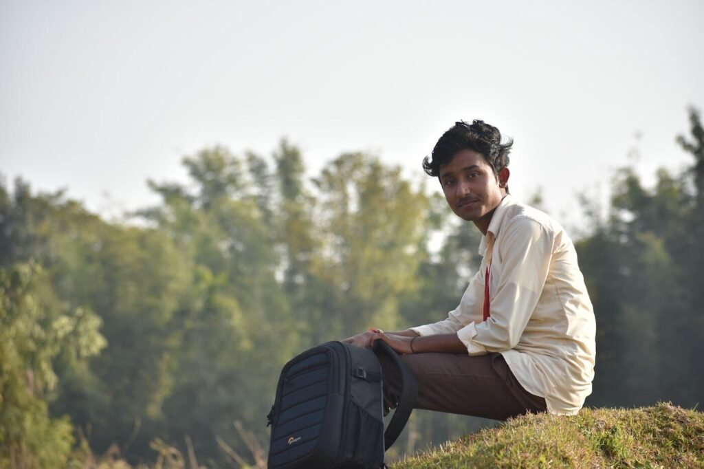 Student sitting outdoors with a backpack